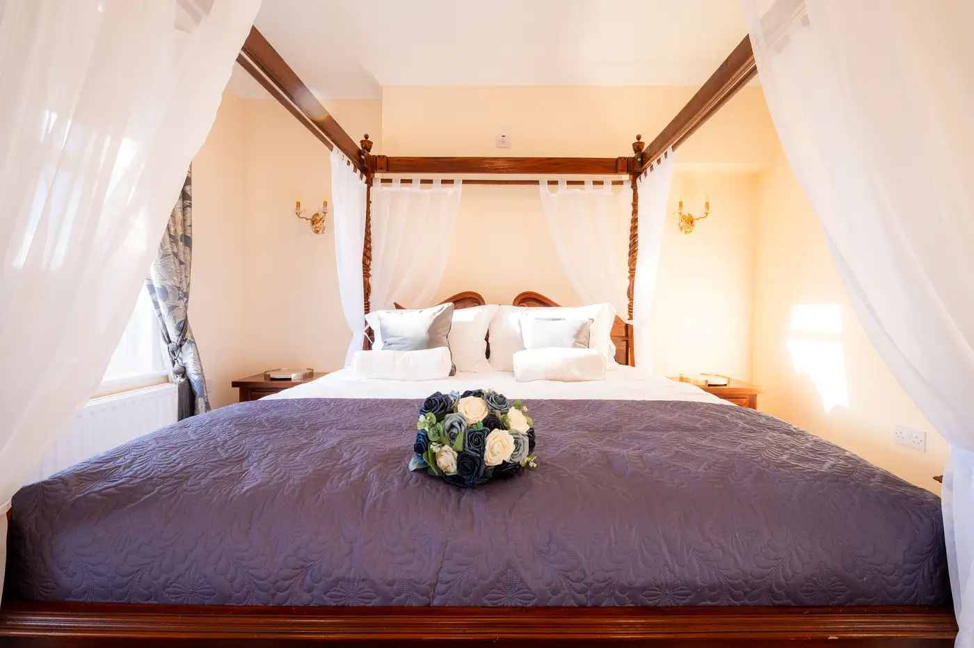 Four-poster bridal suite bed with a wedding bouquet